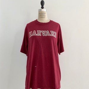 May include: A vintage maroon t-shirt with a white "HARVARD" graphic printed on the front.
