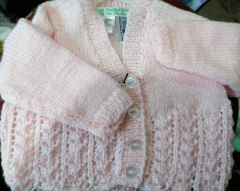 Traditional style, hand knitted, pale pink cardigan with a lacey pattern