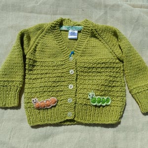 Green, Hand Knitted Acrylic Yarn Childrens Cardigan, with Fun Apple and Caterpillar design on the rear.  Knitted for a child aged 1-2 years