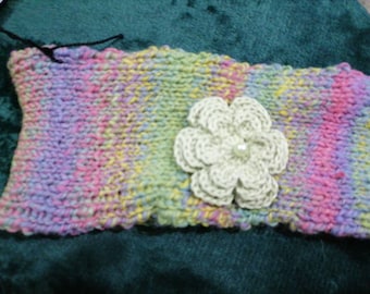 Hand knitted ladies rainbow coloured headband with flower decoration.