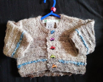 Home spun and hand knitted cardigan knitted to fit a child aged 0-3 months old.