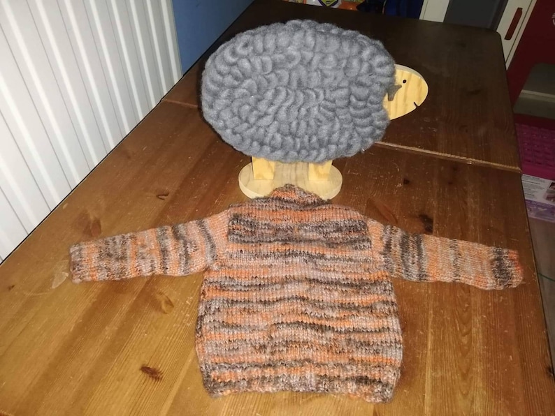 a gorgeous hand knitted cardigan to fit a child aged 0-6 months old Autumn