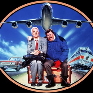 May include: A vintage movie poster featuring two men sitting on a suitcase with a plane flying overhead. The men are wearing casual clothing and smiling. The poster has a blue background with a white border.