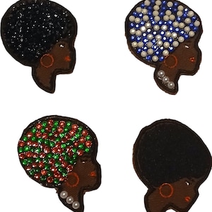May include: Four iron-on patches featuring a profile of a woman with an afro hairstyle. The afros are decorated with rhinestones in black, blue, green, and red.