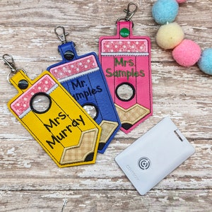 May include: Three yellow, blue, and pink pencil-shaped keychains with clear plastic windows and personalized names: Mrs. Murray, Mr. Imples, and Mrs. Samples.