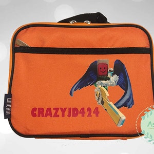 May include: Orange lunch bag with a black zipper and handle. The bag features a graphic of a character with blue wings and a weapon, along with the text "CRAZYJD424". A small tag reads "WIIKIN".