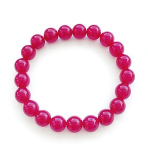 May include: A pink gemstone bracelet with round beads.