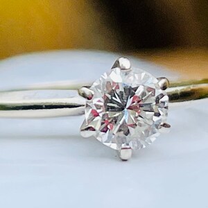 Puede incluir: Un anillo de plata con un solitario redondo de diamante transparente.