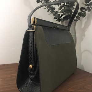 May include: A vintage green and black handbag with a snakeskin pattern and a gold clasp.