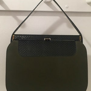 May include: A vintage green and black handbag with a clasp closure. The handbag has a snakeskin pattern on the top flap.