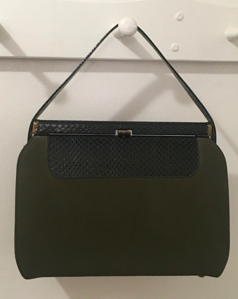 May include: A vintage green and black handbag with a clasp closure. The handbag has a snakeskin pattern on the top flap.