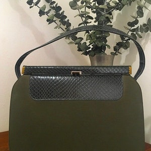 May include: A vintage green handbag with a black snakeskin flap and gold hardware.