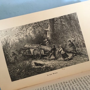 May include: An open book displays a black and white illustration titled "In the Woods." The image depicts a horse-drawn cart loaded with logs, being pulled by people through a wooded area. A dog runs nearby.