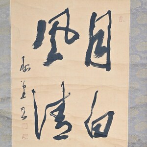 Puede incluir: Un rollo de caligrafía japonés tradicional con tinta negra sobre un fondo beige. El rollo presenta una gran inscripción en caracteres chinos en negrita. Los caracteres están escritos en un estilo fluido y dinámico. El rollo está montado en un rodillo de madera y tiene un borde decorativo.