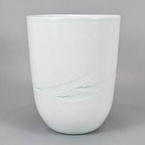 以下が含まれることがあります： 滑らかで丸みを帯びた形をした白い陶器の花瓶。繊細なテクスチャのデザインが施されています。シンプルでエレガントなデザインです。