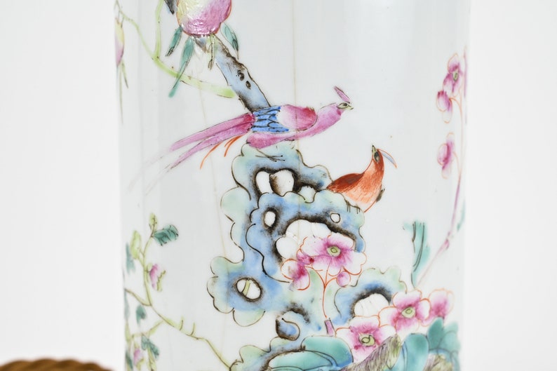 K&ouml;nnte beinhalten: Eine wei&szlig;e Porzellanvase mit einem floralen und Vogelmotiv. Die Vase zeigt ein blaues, gr&uuml;nes und rosa Blumenmuster mit zwei V&ouml;geln, die auf einem Ast sitzen.