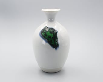 May include: White ceramic vase with a green and blue abstract design.