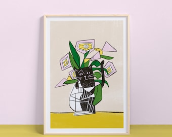 May include: Framed art print featuring a black cat in a vase with green leaves and pink and yellow geometric shapes. The cat is drawn in a whimsical style, with a white and black vase. The background is a light beige color, and the frame is a light wood color.