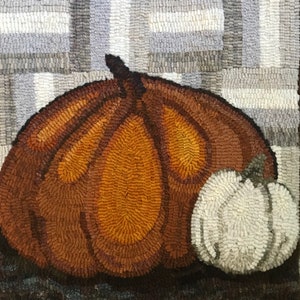 May include: A brown and orange pumpkin with a white pumpkin beside it. Both pumpkins are on a gray and white checkered background.