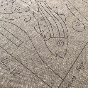 K&ouml;nnte beinhalten: Ein beiger Leinen-Geschirrtuch mit einer schwarzen Linienzeichnung von Fischen und Algen. Der Text "Hootie Rye" ist in der rechten unteren Ecke gedruckt.