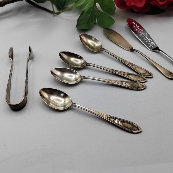 Lovely collection of teaspoons, sugar tongs and two butter knives.