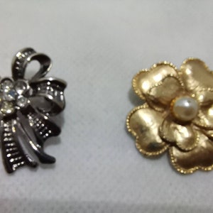 Two vintage brooches. Bow and flower. Black nickel and gold tone. Pearl and rhinestone.
