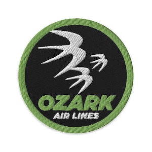 May include: A green and black circular patch with a white stylized bird design and the text "OZARK AIR LINES".