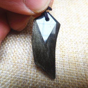 Op de afbeelding: Een zwarte obsidiaan hanger met een puntige vorm en een zwart koord.