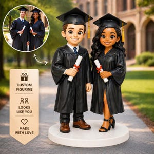 May include: A custom figurine of a graduating couple, dressed in black graduation gowns and caps, holding diplomas. The figurine is on a white base, with a small inset image of the couple in real life. The text on the side says "Custom Figurine", "Looks Like You", and "Made With Love".