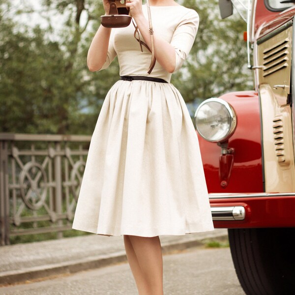 Golden corolle dress with its black satiny belt