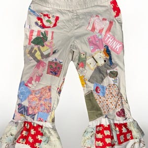 Puede incluir: Pantalones color crema con diseños de patchwork coloridos. Los parches incluyen patrones florales, animales y geométricos. La palabra "THINK" está en un parche rosa. Los pantalones tienen dobladillos con volantes.