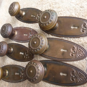 May include: A white ceramic mug with a black handle and the text "But First, Coffee" in a black, bold font. The mug is on a white surface. The mug is 10 cm tall.