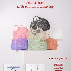 Pu&ograve; includere: Un set di otto borse di gelatina in vari colori, tra cui beige, bianco, rosa, verde, viola, arancione e nero. Le borse sono realizzate in materiale a rete e hanno un manico. Le borse sono impilate l'una sull'altra. Il testo "JELLY BAG with custom holder tag" &egrave; nella parte superiore dell'immagine. Il testo "Color Options" &egrave; nella parte inferiore dell'immagine. Il testo "BEIGE, WHITE, PINK, GREEN, PURPLE, ORANGE, BLACK" &egrave; elencato sotto il testo "Color Options".