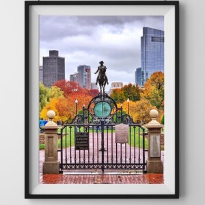 May include: A black wrought iron gate with a sign that reads "Bicycling & Roller Blading Prohibited" in front of a park with fall foliage and a statue of a man on horseback in the background.