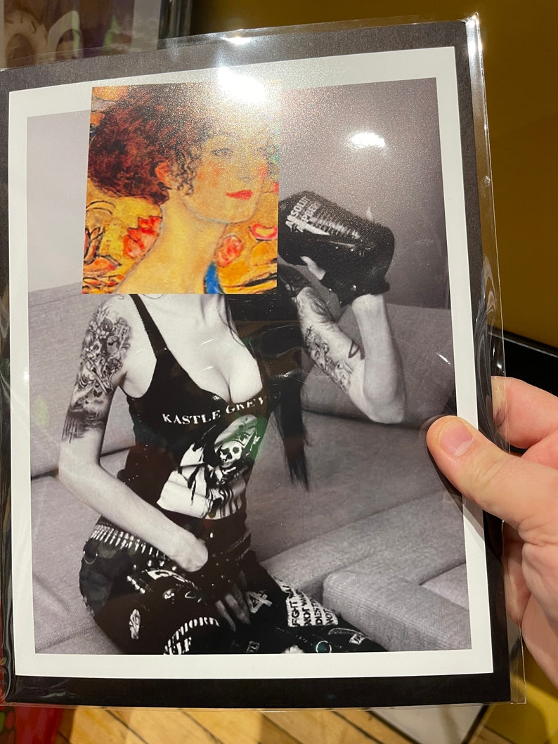 May include: A black and white print featuring a woman in a tank top with the text "KASTLE GREY" and a skull graphic. The print also includes a section of a painting and a person holding a bottle.