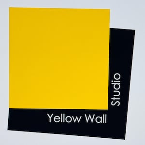 May include: A graphic design featuring a bright yellow square overlapping a black rectangle. The text "Yellow Wall" is displayed in white at the bottom, with "Studio" in white text on the side.