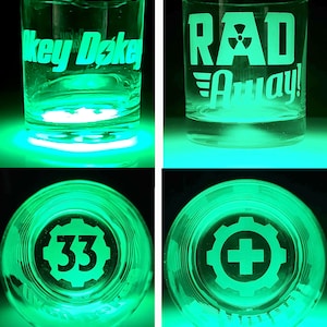 May include: Four different designs of a clear glass tumbler with a green glow. The designs include the text "Okey Dokey", "RAD Away!" with a radiation symbol, a gear with the number 33, and a gear with a plus sign.