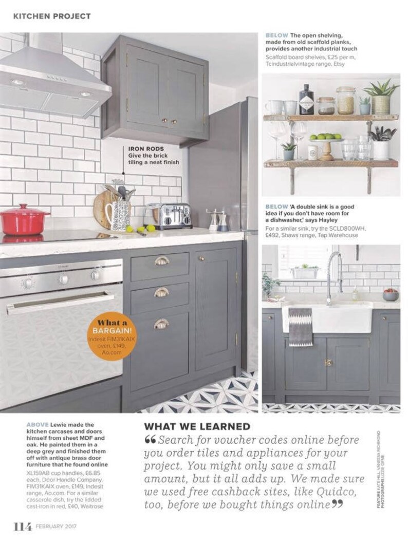 May include: A gray kitchen with white subway tile backsplash, gray cabinets, and a white farmhouse sink. The kitchen features open shelving made from scaffold planks, a double sink, and a brick tiled floor. The text "What a Bargain!" is visible in a red circle.