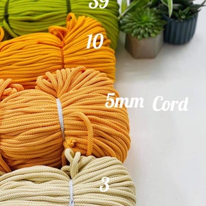 May include: Four spools of 5mm cotton cord in different colors: green, yellow, orange, and cream. The spools are labeled with the number of meters of cord on each spool: 39, 10, 5mm Cord, and 3.