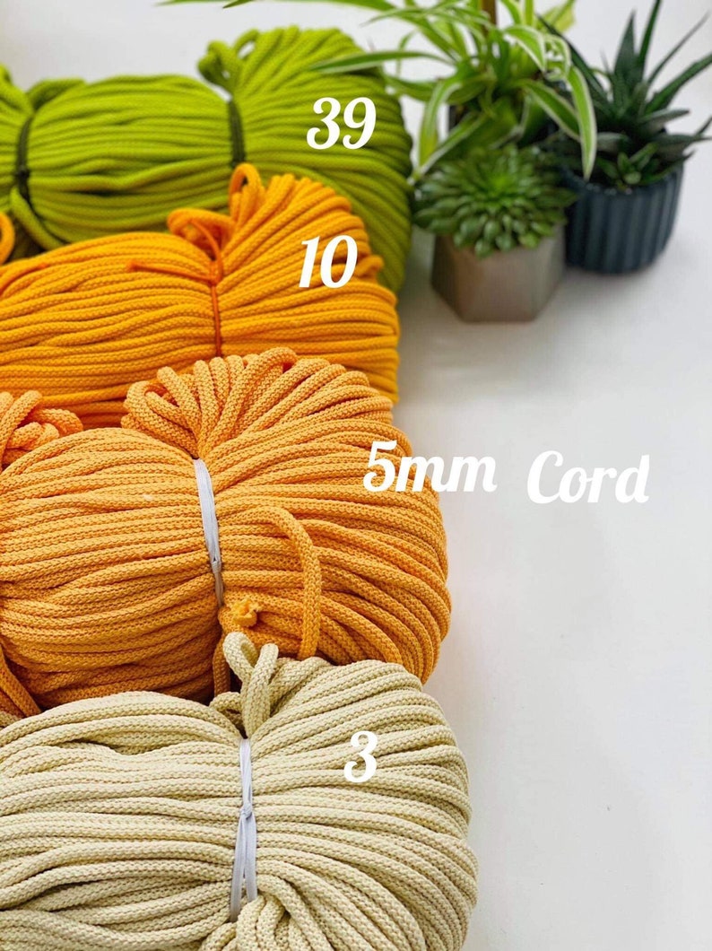 May include: Four spools of 5mm cotton cord in different colors: green, yellow, orange, and cream. The spools are labeled with the number of meters of cord on each spool: 39, 10, 5mm Cord, and 3.