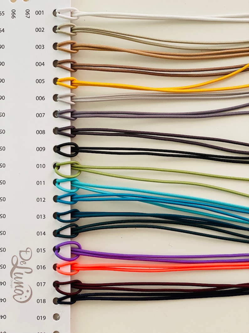 Puede incluir: Una carta de colores que muestra varios cordones el&aacute;sticos en una gama de colores. Los cordones est&aacute;n numerados e incluyen tonos de blanco, beige, marr&oacute;n, amarillo, gris, negro, verde azulado, azul, morado, naranja y burdeos. Los cordones est&aacute;n en bucle en la parte superior.