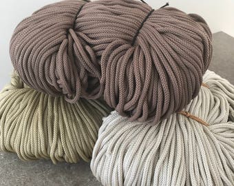 Puede incluir: Tres carretes de cuerda de algodón en diferentes colores: marrón, beige y verde. La cuerda es gruesa y texturizada, perfecta para manualidades.