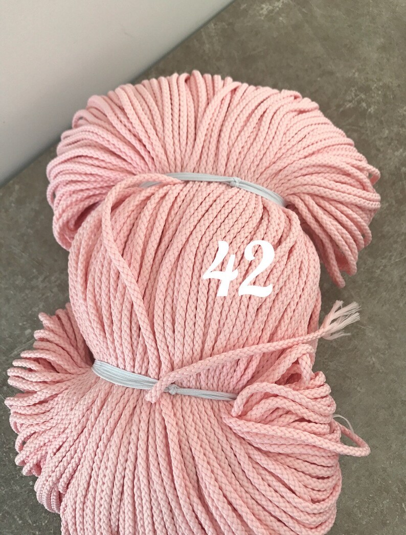 May include: A large spool of pink cotton cord, with the number 42 printed on the side.