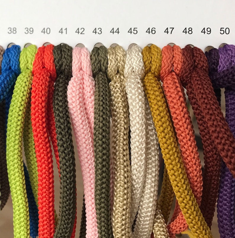 May include: A colour chart of 13 different colours of cord, numbered 38 to 50. The cords are all the same thickness and texture.
