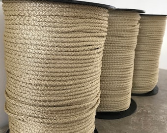 May include: Three spools of beige braided rope, each wound around a black plastic spool.