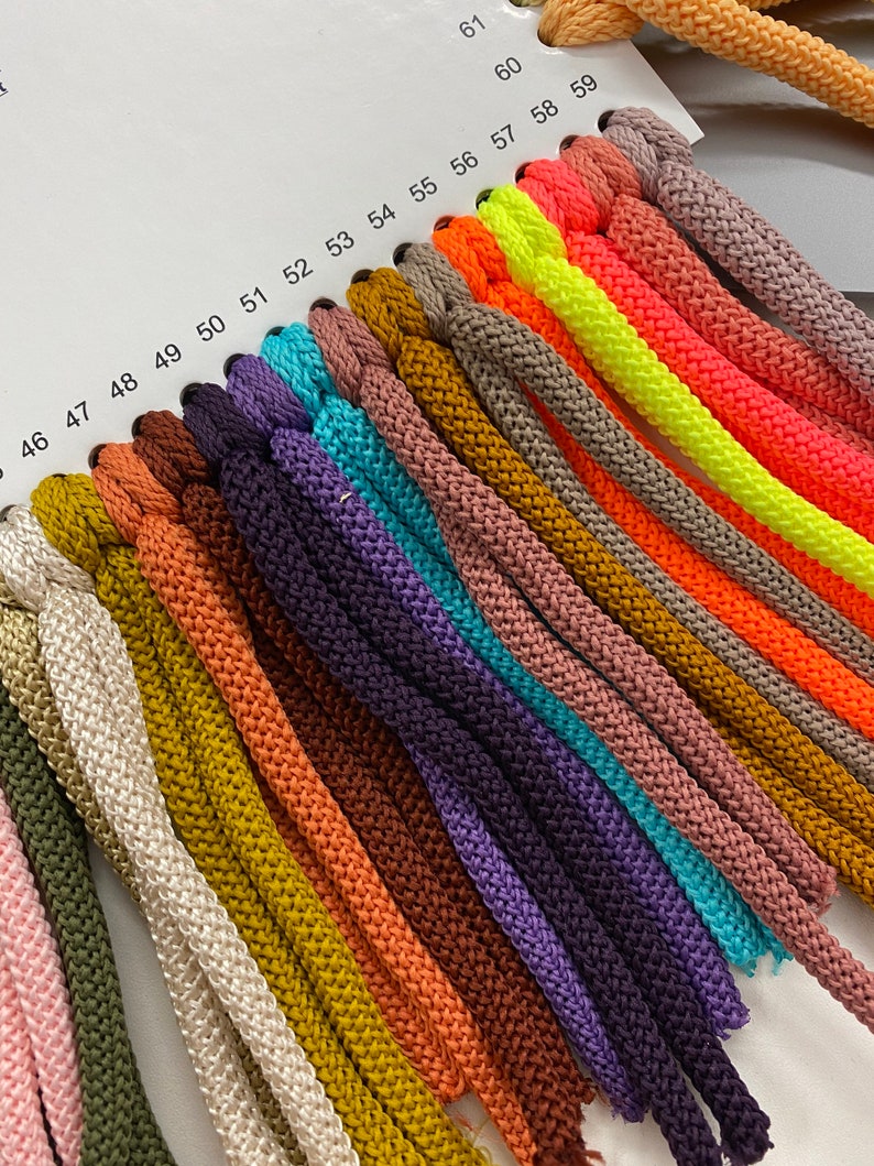 May include: A colour chart of 16 different shades of cord, ranging from light pink to bright yellow. The cords are numbered 46 to 61.
