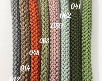 May include: A collection of eight parallel braided cords in various colours including grey, tan, orange, olive, pink, light green, and dark green. Each cord is labelled with a white numerical identifier: 012, 014, 048, 063, 059, 062, 041, and 064.