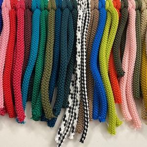 May include: A selection of 21 different coloured cords, ranging from dark red to light pink, with numbers 24 to 44 printed above each cord.