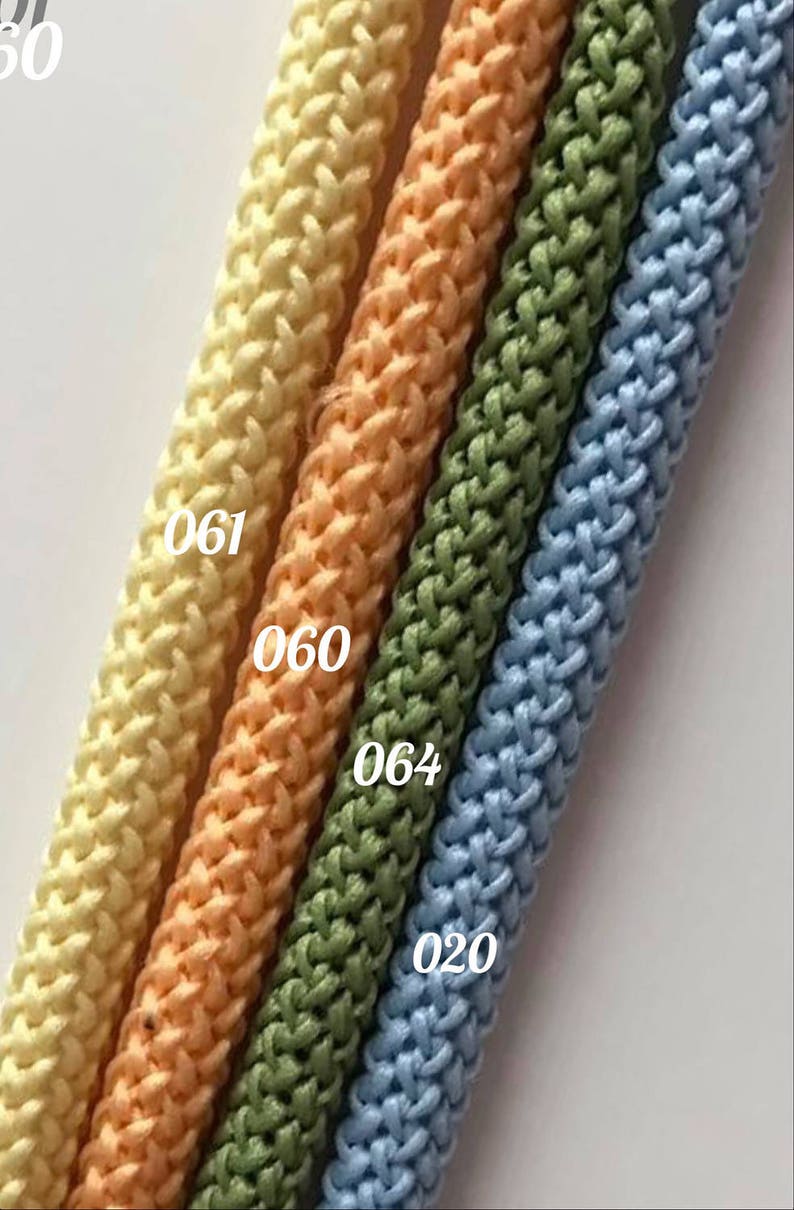 May include: Four different colors of braided cord, from left to right: light yellow, peach, green, and light blue. The cords are labeled with numbers: 061, 060, 064, and 020.