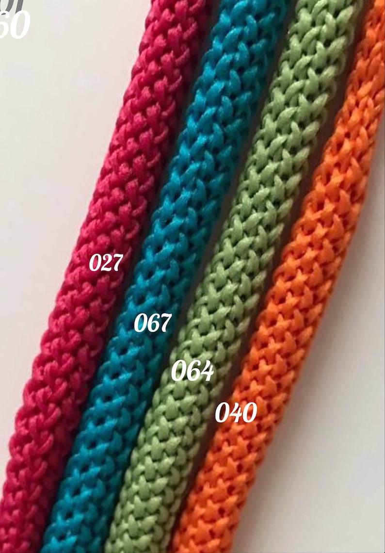 May include: Four spools of braided cord in different colors: red, teal, green, and orange. The spools are labeled with numbers: 027, 067, 064, and 040.